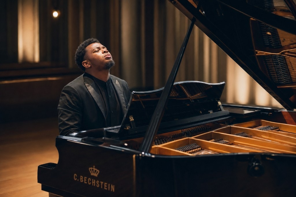 Ato Baah-Nyarkoh at a Bechstein grand piano, eyes closed in performance.