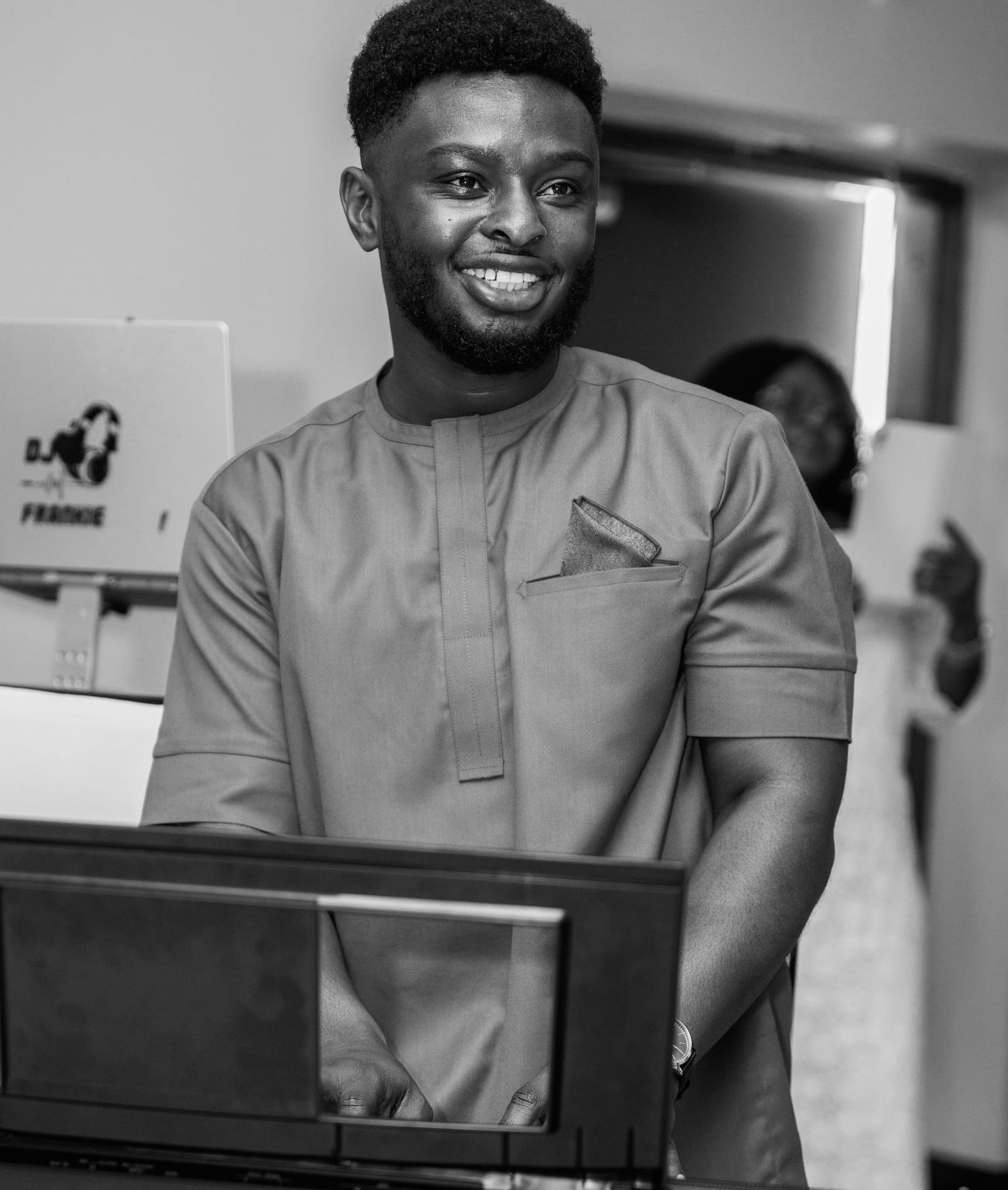 Black and white portrait of Ato Baah-Nyarkoh at a keyboard in a studio setting.